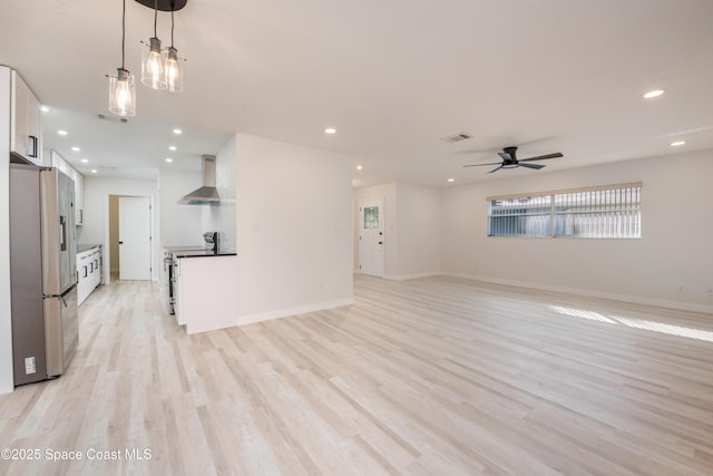 unfurnished living room with recessed lighting, light wood-style flooring, a ceiling fan, and baseboards