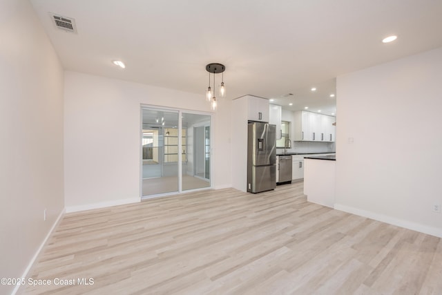 unfurnished living room featuring recessed lighting, light wood-style floors, visible vents, and baseboards