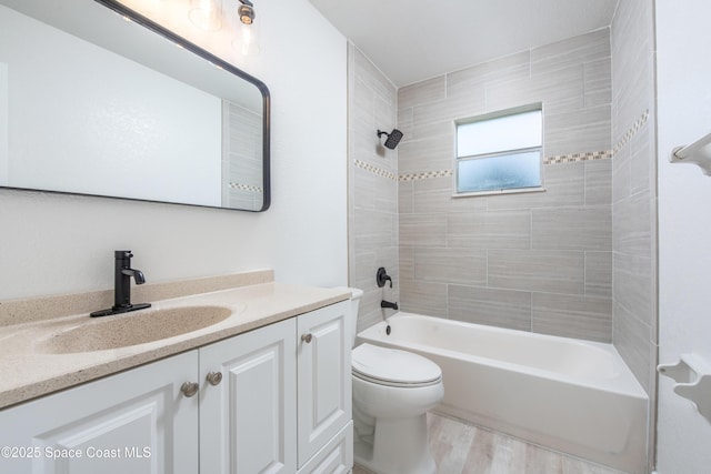 full bath featuring wood finished floors, toilet, vanity, and washtub / shower combination