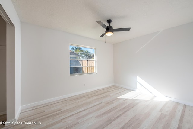 unfurnished room with baseboards, a textured ceiling, a ceiling fan, and wood finished floors