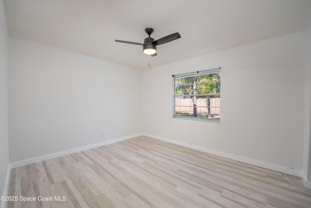 spare room featuring a ceiling fan, baseboards, and light wood finished floors