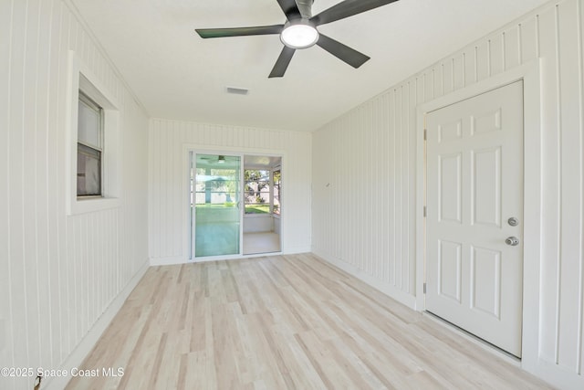 spare room with visible vents, light wood finished floors, and ceiling fan