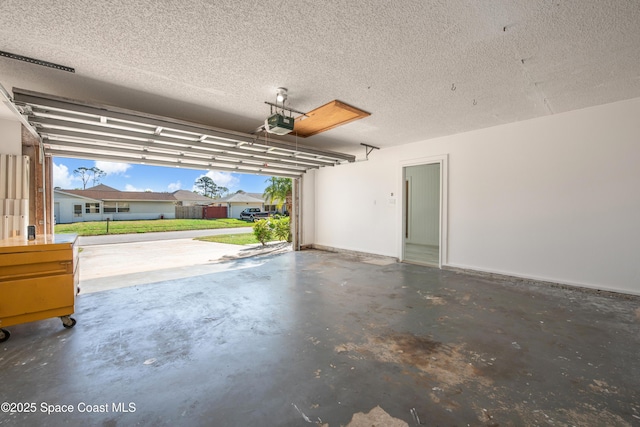 garage featuring a garage door opener and baseboards