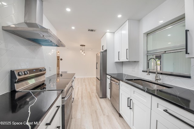 kitchen featuring a sink, wall chimney exhaust hood, backsplash, and stainless steel appliances