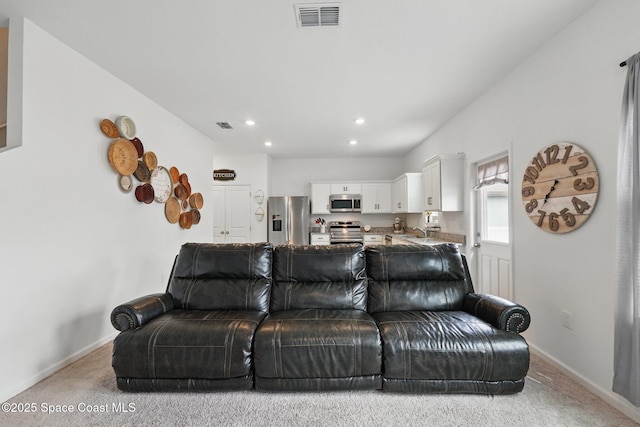 living area featuring visible vents, carpet floors, and baseboards