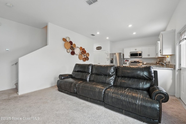 living room with recessed lighting, visible vents, light carpet, and stairs