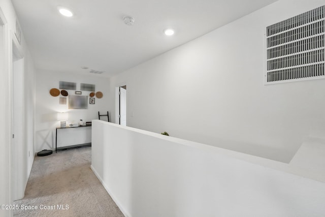 hall featuring recessed lighting, an upstairs landing, visible vents, and carpet floors