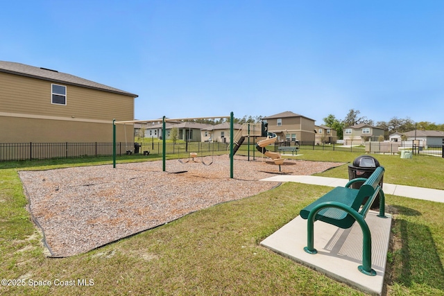 communal playground with a residential view, a lawn, and fence