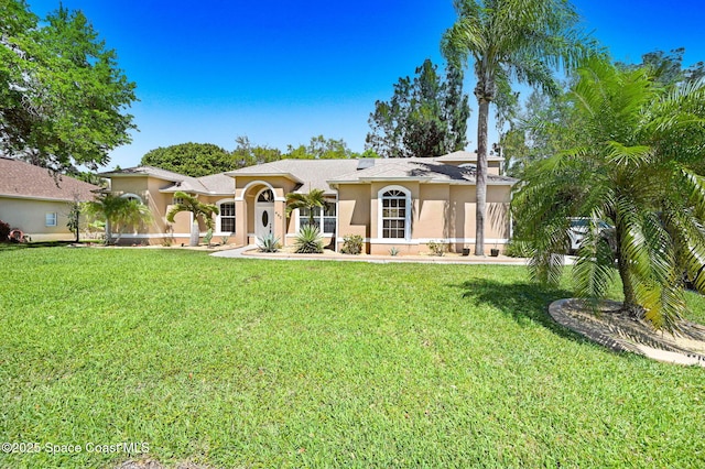 mediterranean / spanish house featuring a front lawn and stucco siding