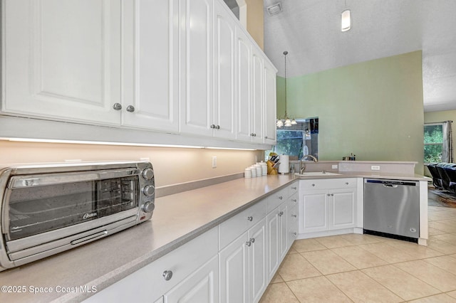 kitchen with dishwasher, light countertops, a peninsula, white cabinets, and a sink