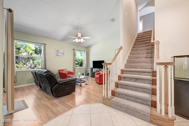 living area with tile patterned floors, stairway, and a wealth of natural light