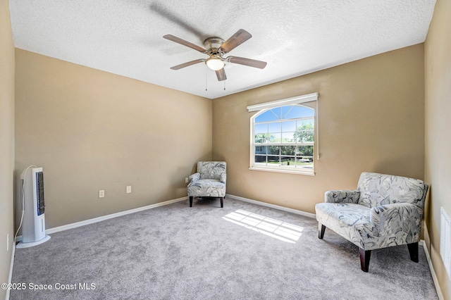 living area featuring a ceiling fan, baseboards, carpet floors, and a textured ceiling