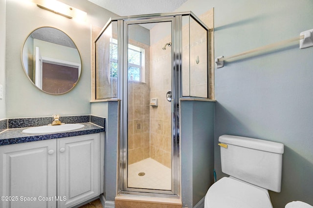 full bathroom featuring a stall shower, toilet, and vanity