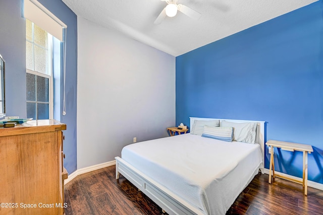 bedroom featuring a textured ceiling, wood finished floors, baseboards, and ceiling fan