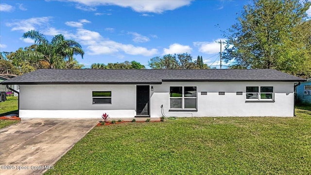 view of front of property featuring stucco siding, a front lawn, and roof with shingles