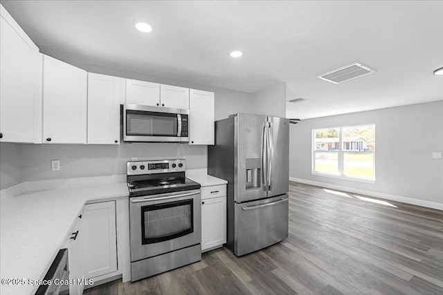 kitchen featuring dark wood finished floors, visible vents, white cabinetry, and stainless steel appliances