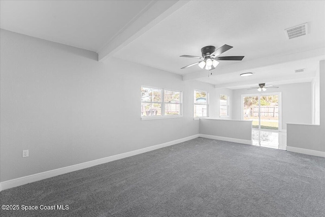 unfurnished room with visible vents, plenty of natural light, beamed ceiling, and carpet flooring