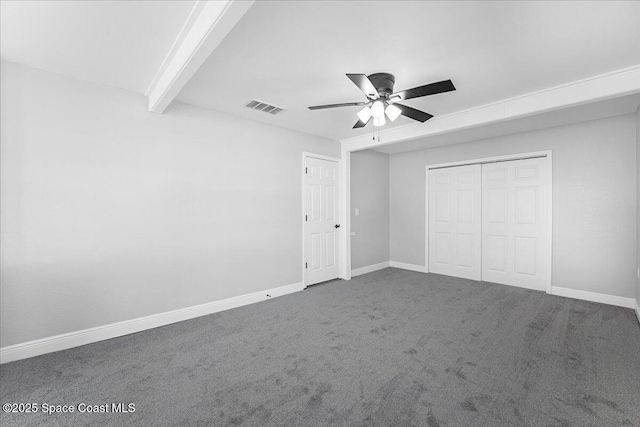 unfurnished bedroom with beamed ceiling, visible vents, carpet flooring, and baseboards