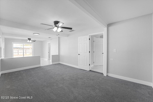 spare room featuring a ceiling fan, baseboards, visible vents, and dark colored carpet