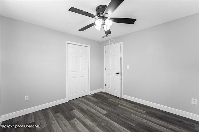 unfurnished bedroom with visible vents, baseboards, dark wood-type flooring, and ceiling fan