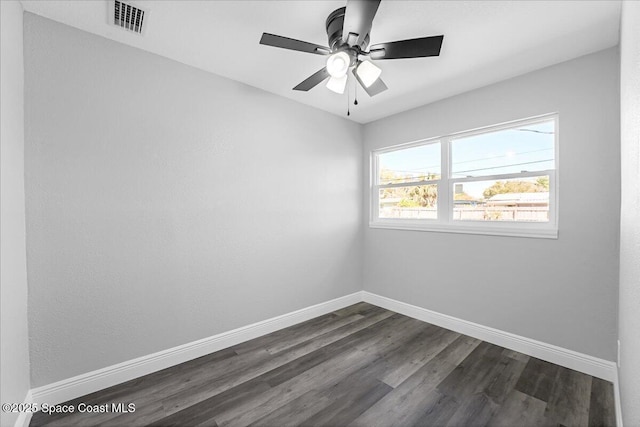 spare room with visible vents, ceiling fan, baseboards, and dark wood-style flooring