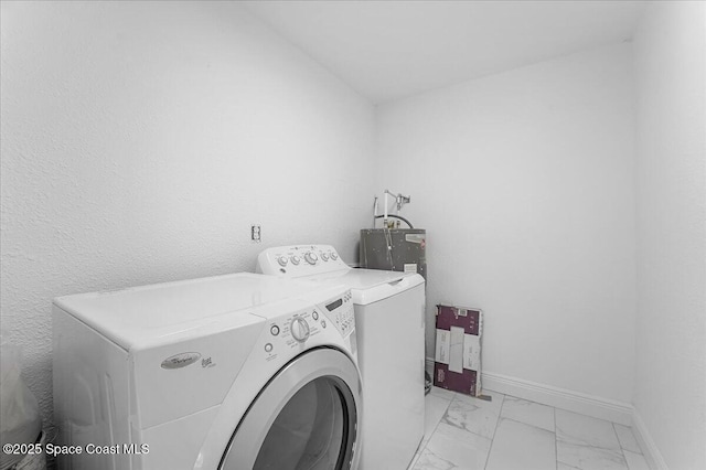 laundry area with independent washer and dryer, laundry area, baseboards, and marble finish floor