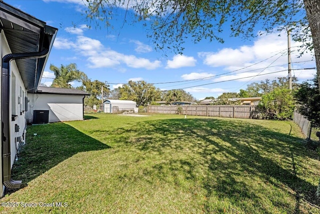 view of yard featuring central AC and fence