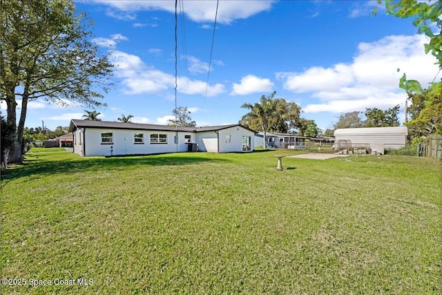 back of house featuring a lawn and fence