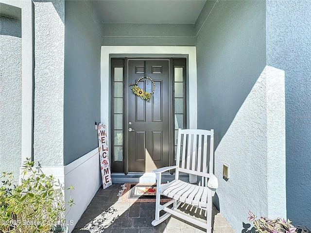 doorway to property featuring stucco siding