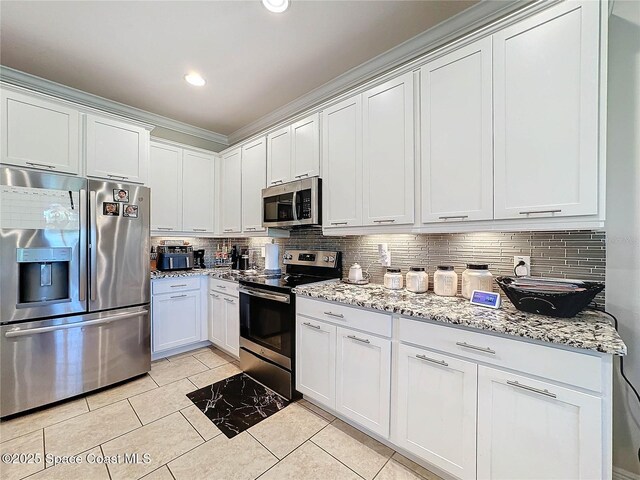 kitchen with light stone counters, tasteful backsplash, white cabinetry, recessed lighting, and appliances with stainless steel finishes