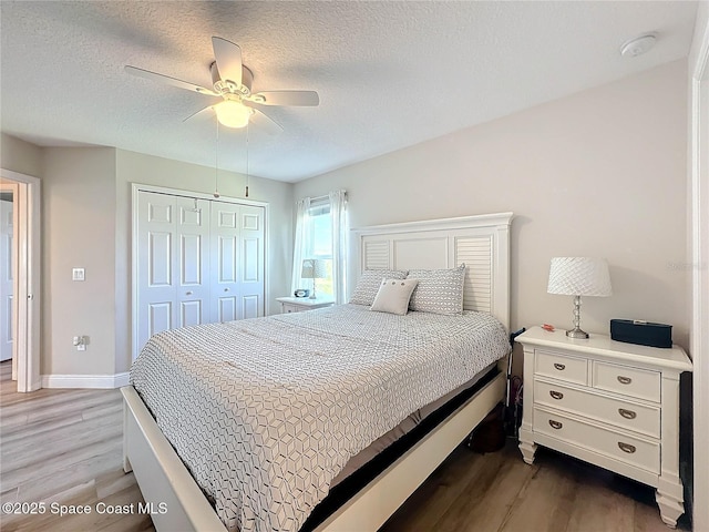 bedroom featuring light wood-style flooring, a ceiling fan, a closet, and a textured ceiling