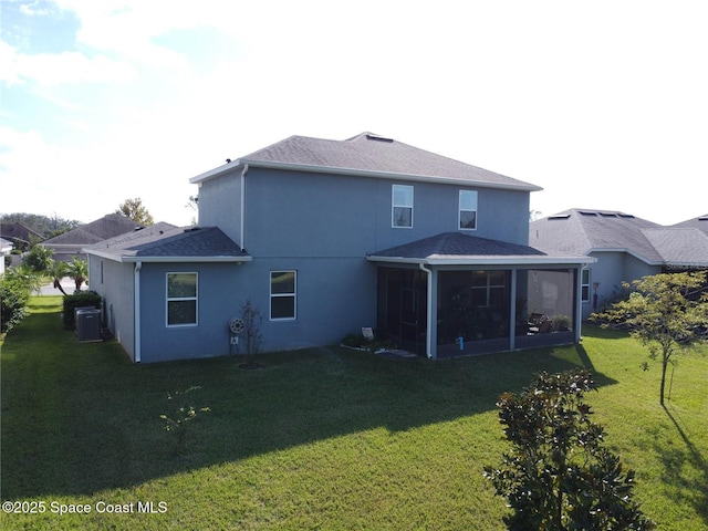 back of property with central air condition unit, roof with shingles, a lawn, stucco siding, and a sunroom