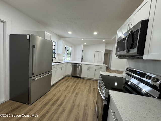 kitchen featuring a sink, light wood-style floors, appliances with stainless steel finishes, and white cabinets