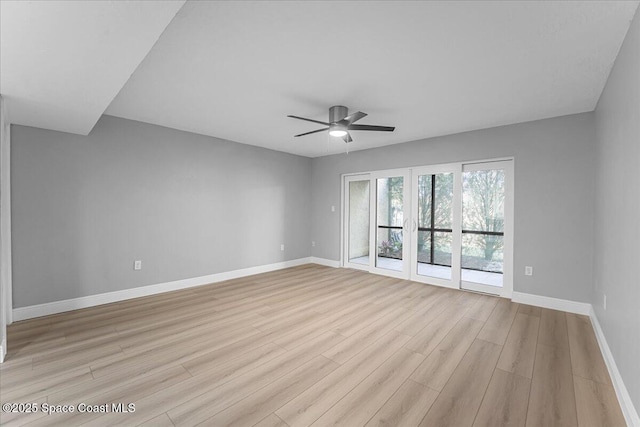 spare room featuring a ceiling fan, light wood-type flooring, and baseboards