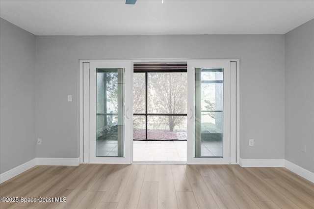 entryway featuring wood finished floors, baseboards, and ceiling fan