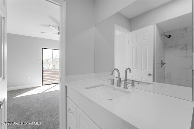 bathroom with ceiling fan, vanity, baseboards, and walk in shower