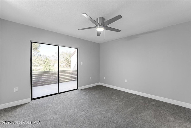 empty room featuring a ceiling fan, baseboards, dark carpet, and a textured ceiling