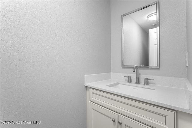 bathroom featuring vanity and a textured wall