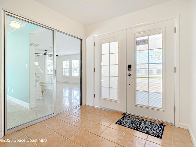 doorway to outside featuring light tile patterned flooring, french doors, and baseboards