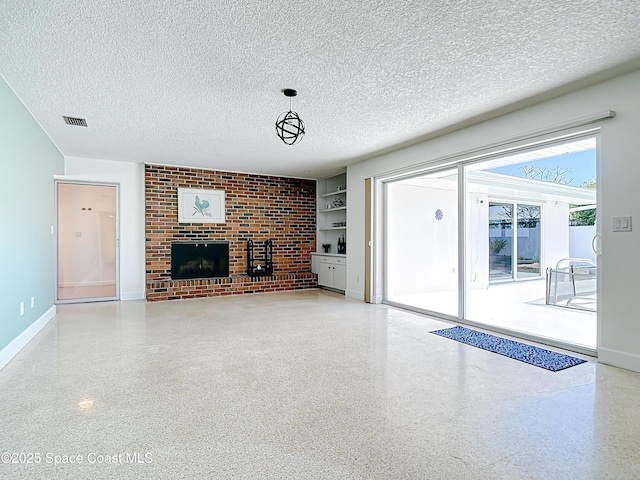 unfurnished living room with built in features, visible vents, speckled floor, a textured ceiling, and a brick fireplace