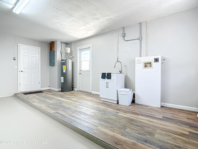 interior space with laundry area, hookup for a washing machine, wood finished floors, and electric water heater