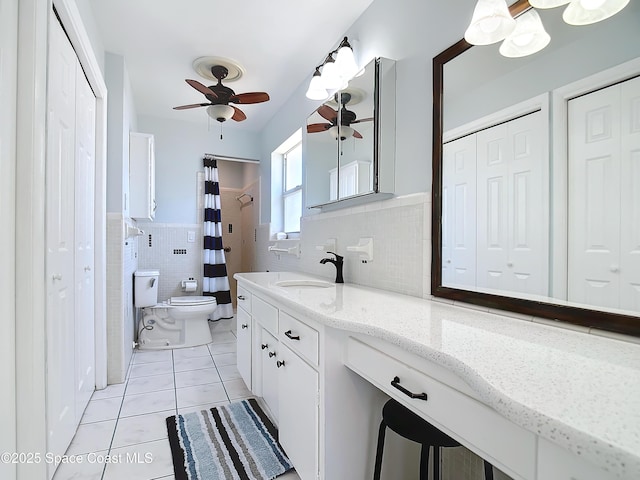 bathroom featuring curtained shower, tile walls, toilet, tile patterned floors, and vanity