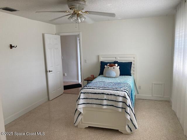 bedroom with visible vents, ceiling fan, a textured ceiling, and baseboards