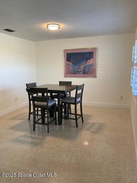 dining space featuring visible vents, baseboards, a textured ceiling, and speckled floor