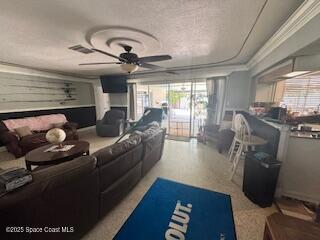 living room featuring visible vents, ceiling fan, and ornamental molding