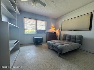 sitting room featuring speckled floor and ceiling fan