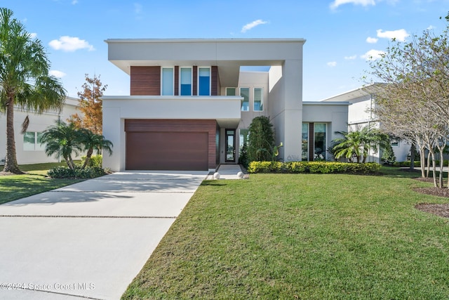 modern home featuring a front yard, concrete driveway, a garage, and stucco siding