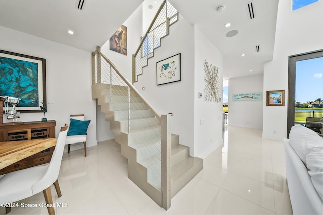 stairway featuring tile patterned floors, visible vents, and recessed lighting