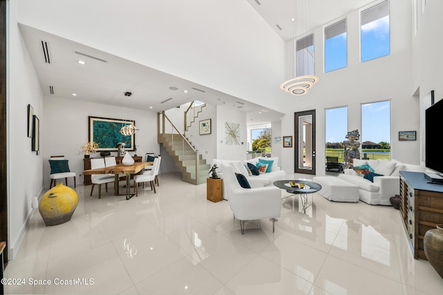 living room with a wealth of natural light, stairway, and light tile patterned flooring