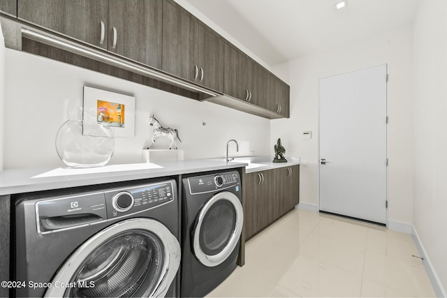 washroom featuring baseboards, light tile patterned flooring, cabinet space, a sink, and independent washer and dryer